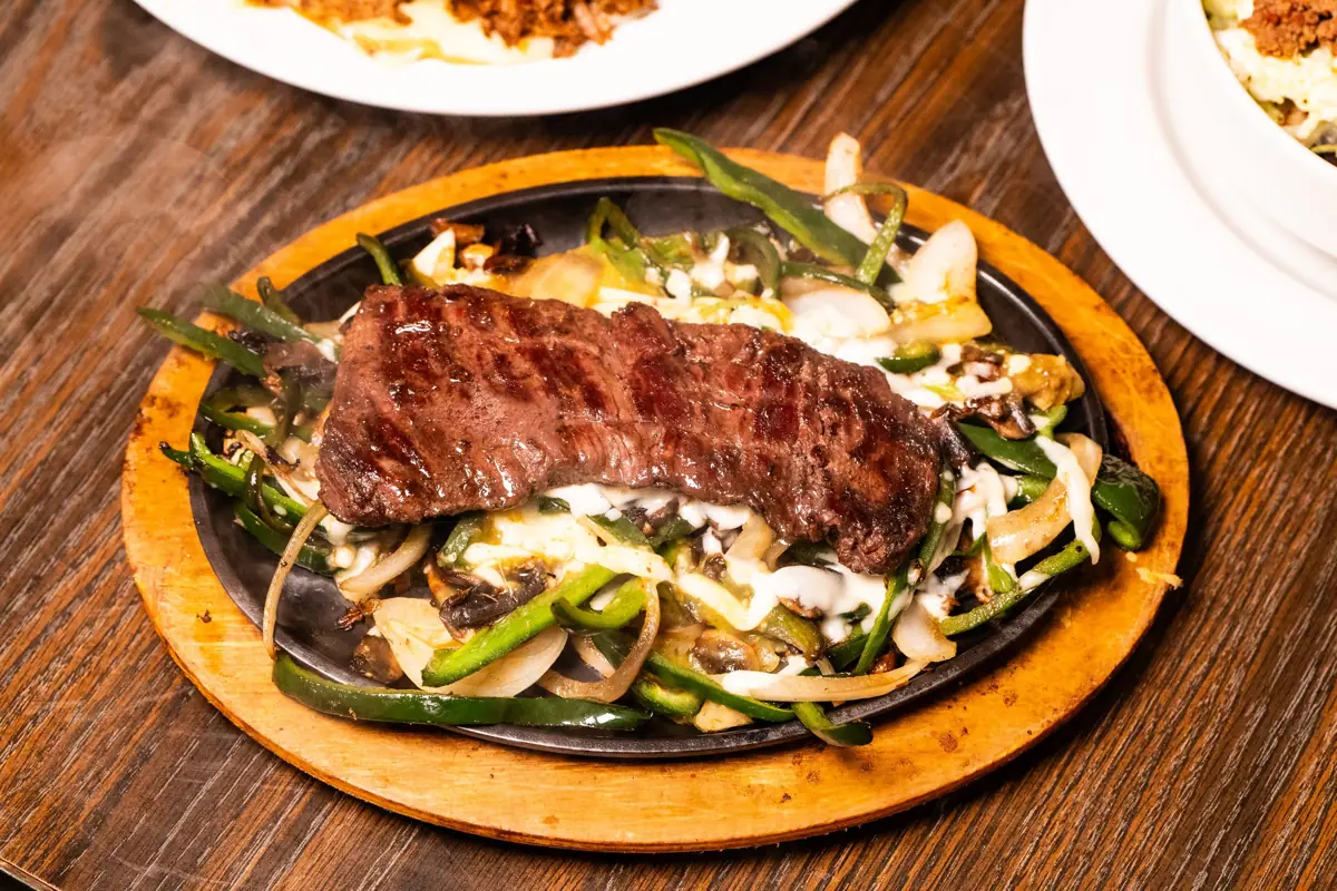 La Poblana: grilled steak over poblano peppers, onions and mushrooms on a sizzling platter
